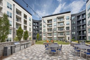 Serene courtyard with outdoor grilling & bistro lighting